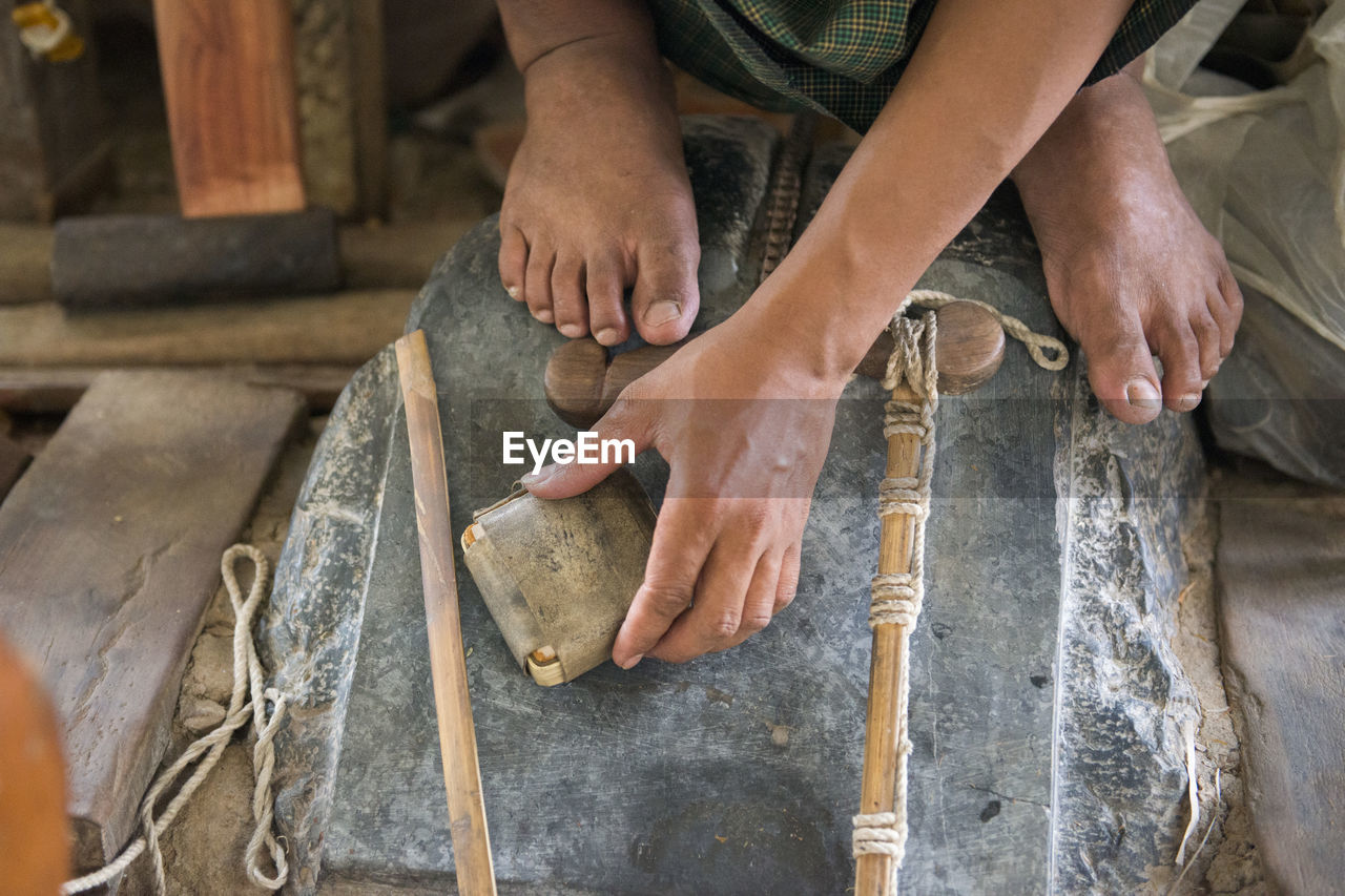 Cropped image of man working on stone at workshop