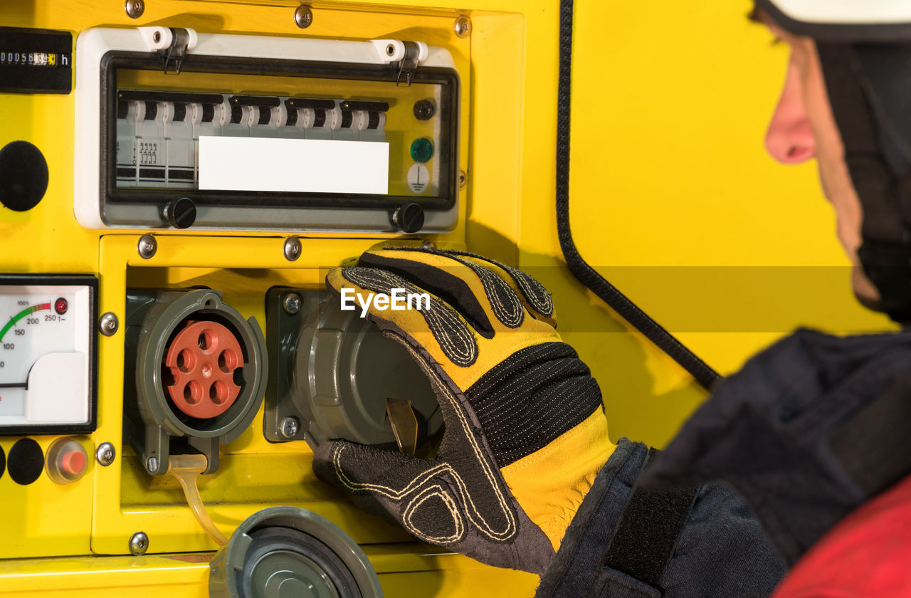 CLOSE-UP OF MAN WORKING ON YELLOW