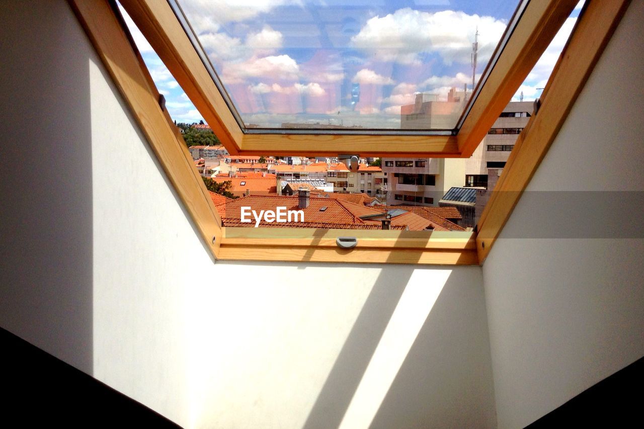 Low angle view of cityscape seen through skylight