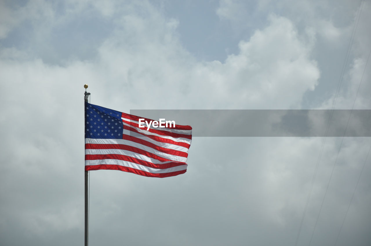 Low angle view of american flag against sky