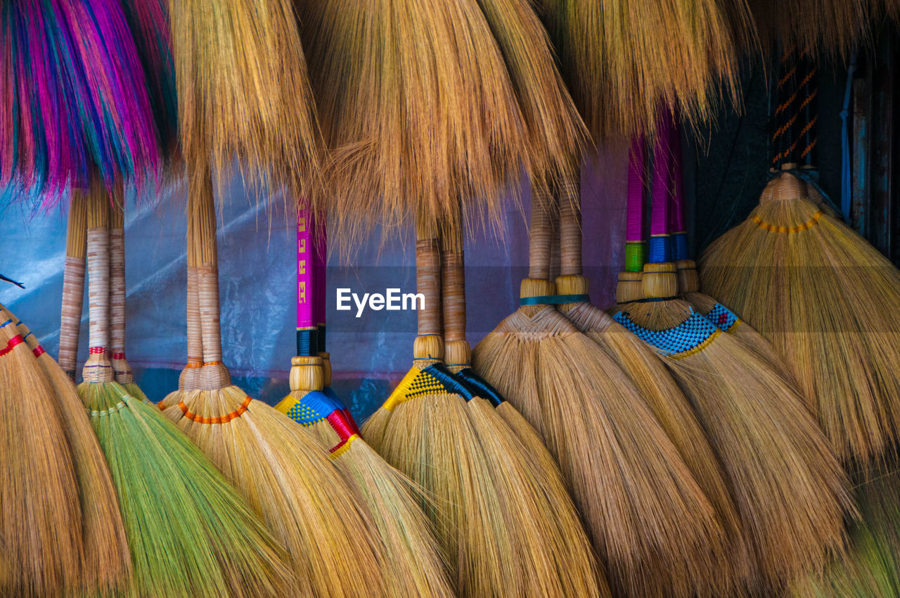 Close-up of brooms for sale at market stall