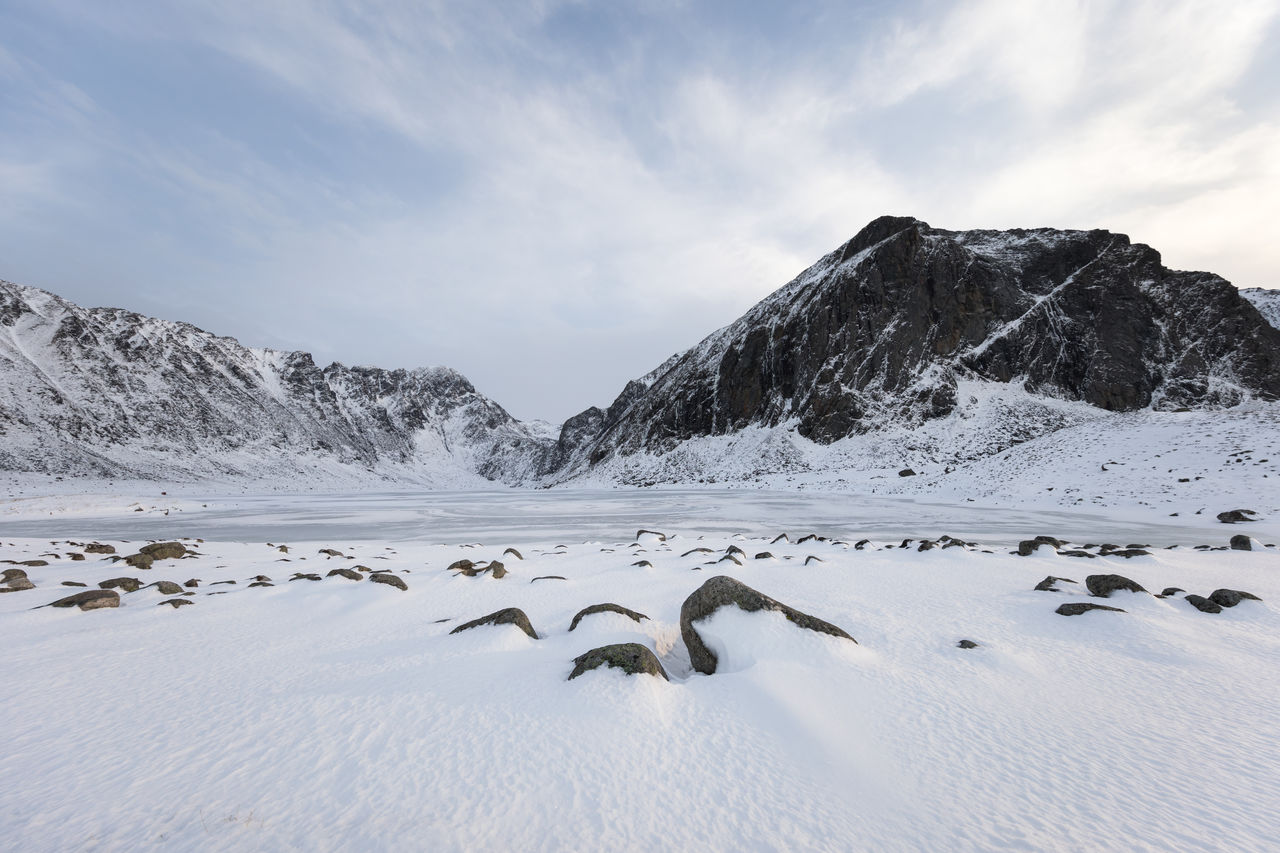 Scenic view of frozen lake by mountains against sky at lofoten