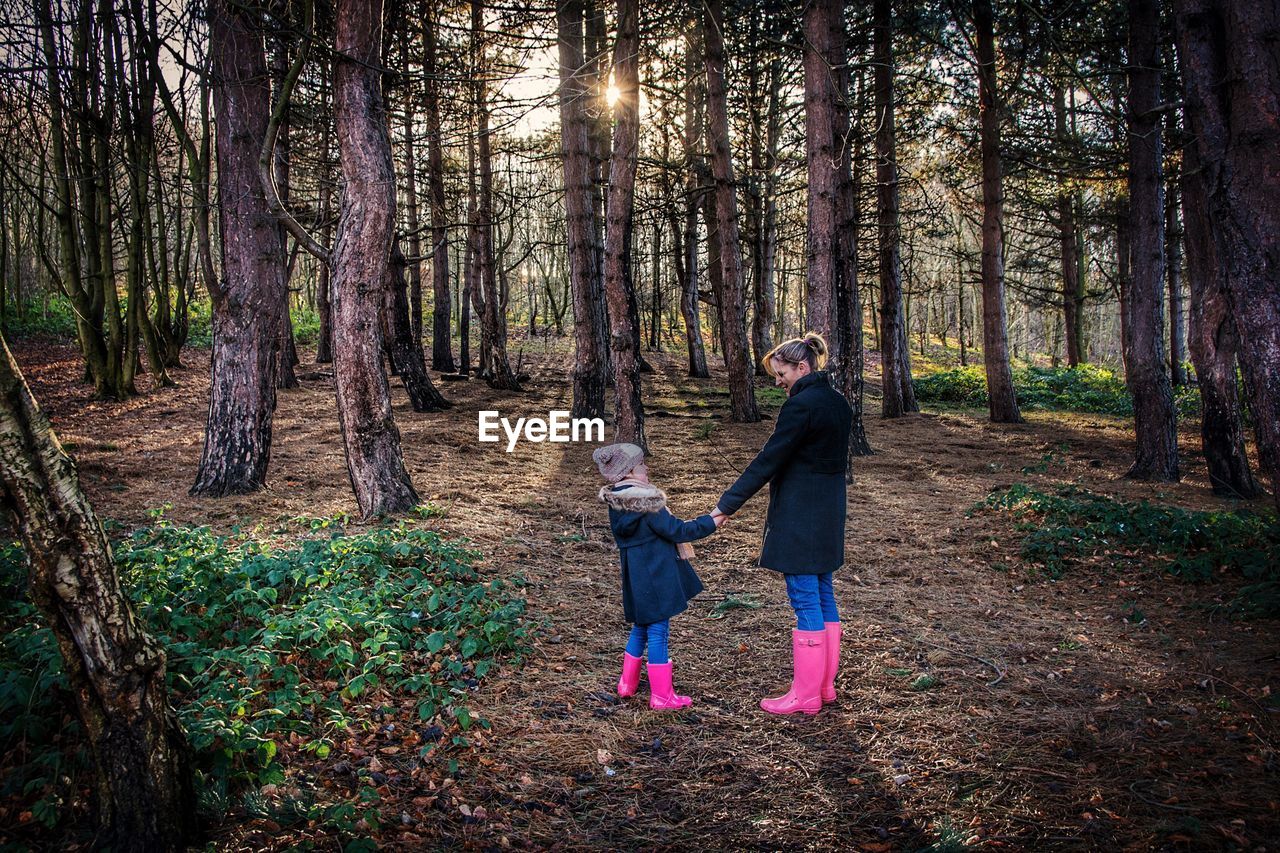 People holding hands in forest