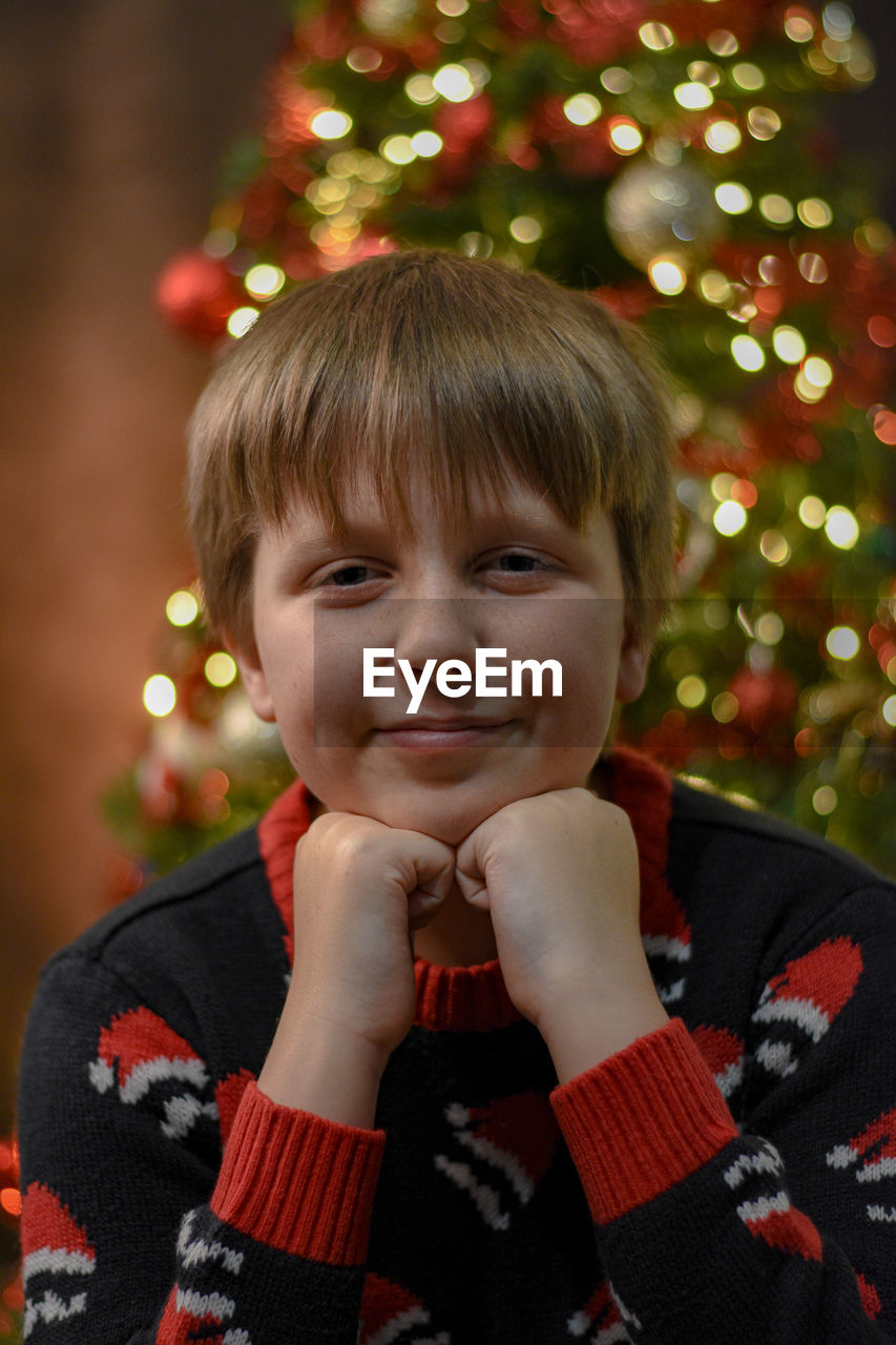 Portrait of cute boy in front of christmas tree 