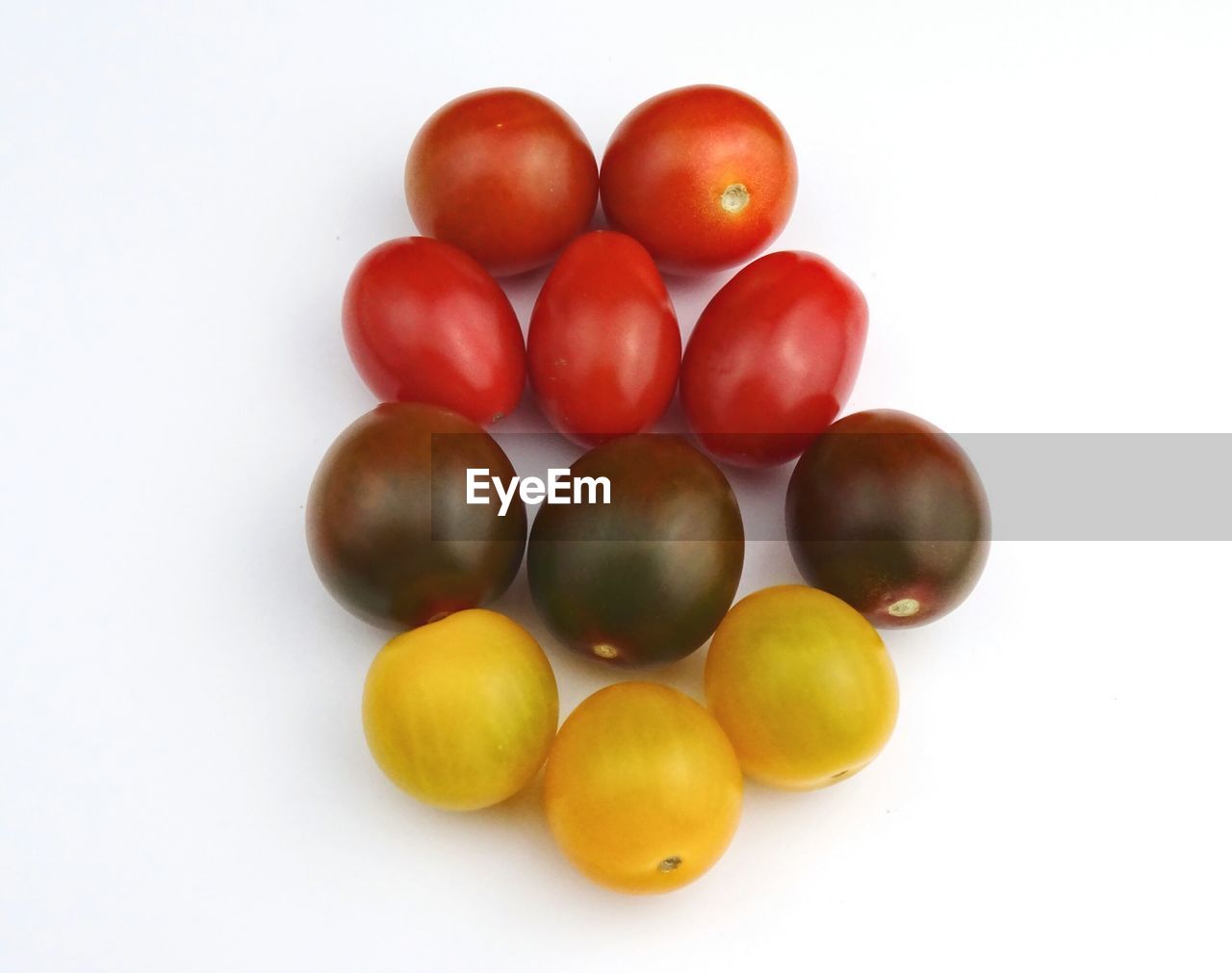 Close-up of various tomatoes over white background