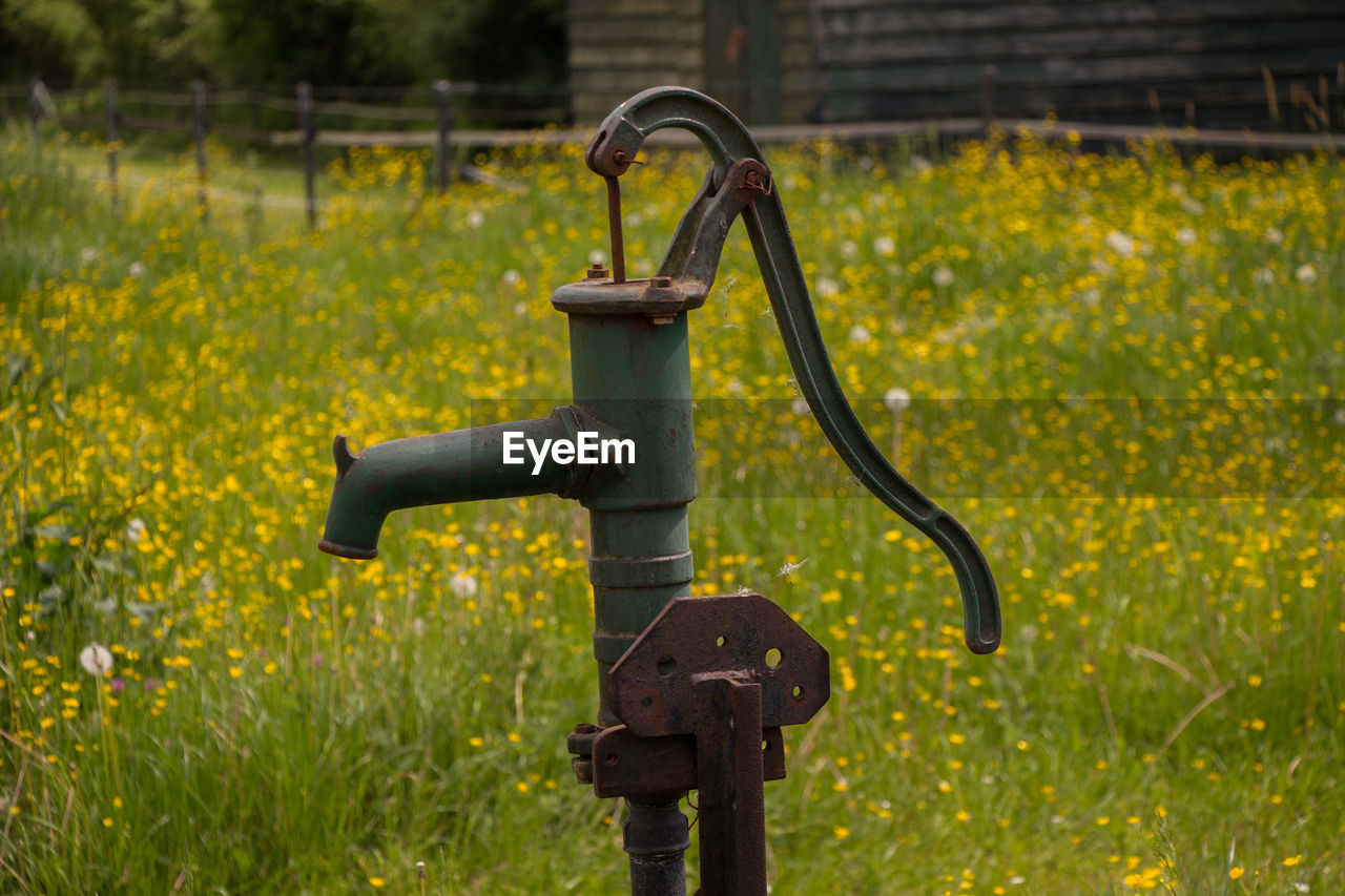 CLOSE-UP OF METAL PIPE ON FIELD