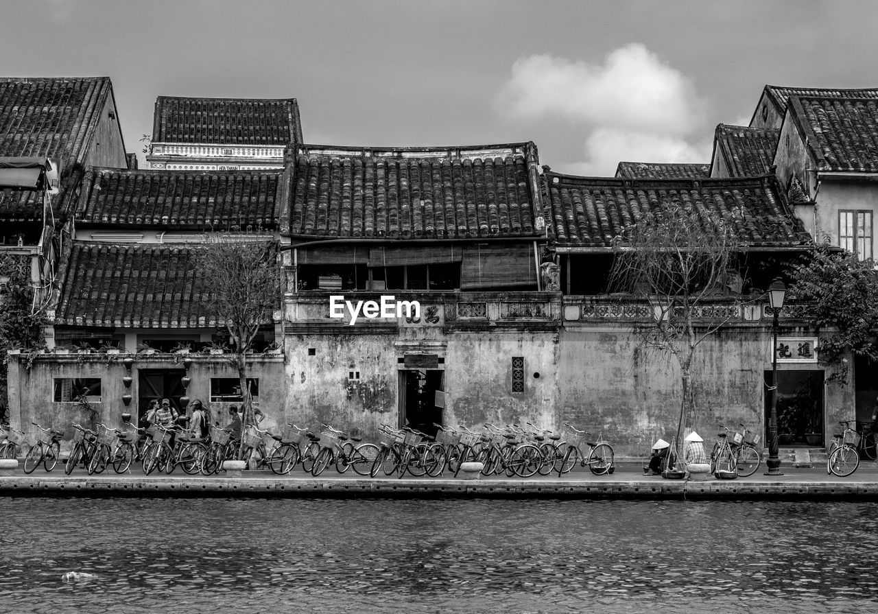 Riverside houses against sky