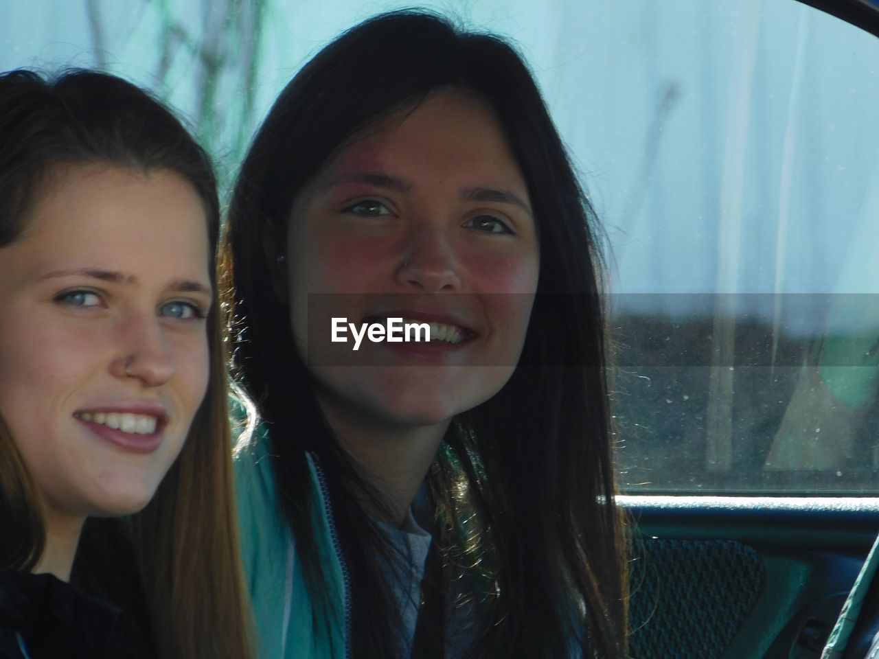 Close-up portrait of smiling young women in car