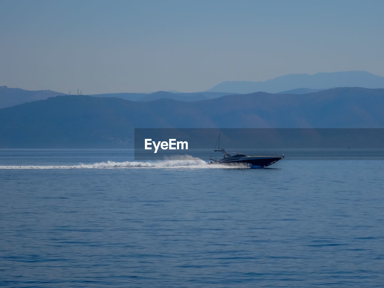 Boat sailing on sea against clear sky