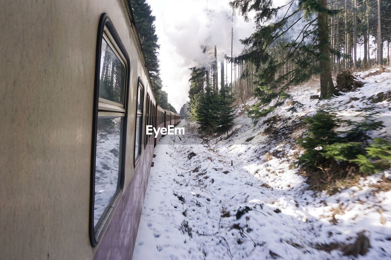 Close-up of train passing through snow covered landscape
