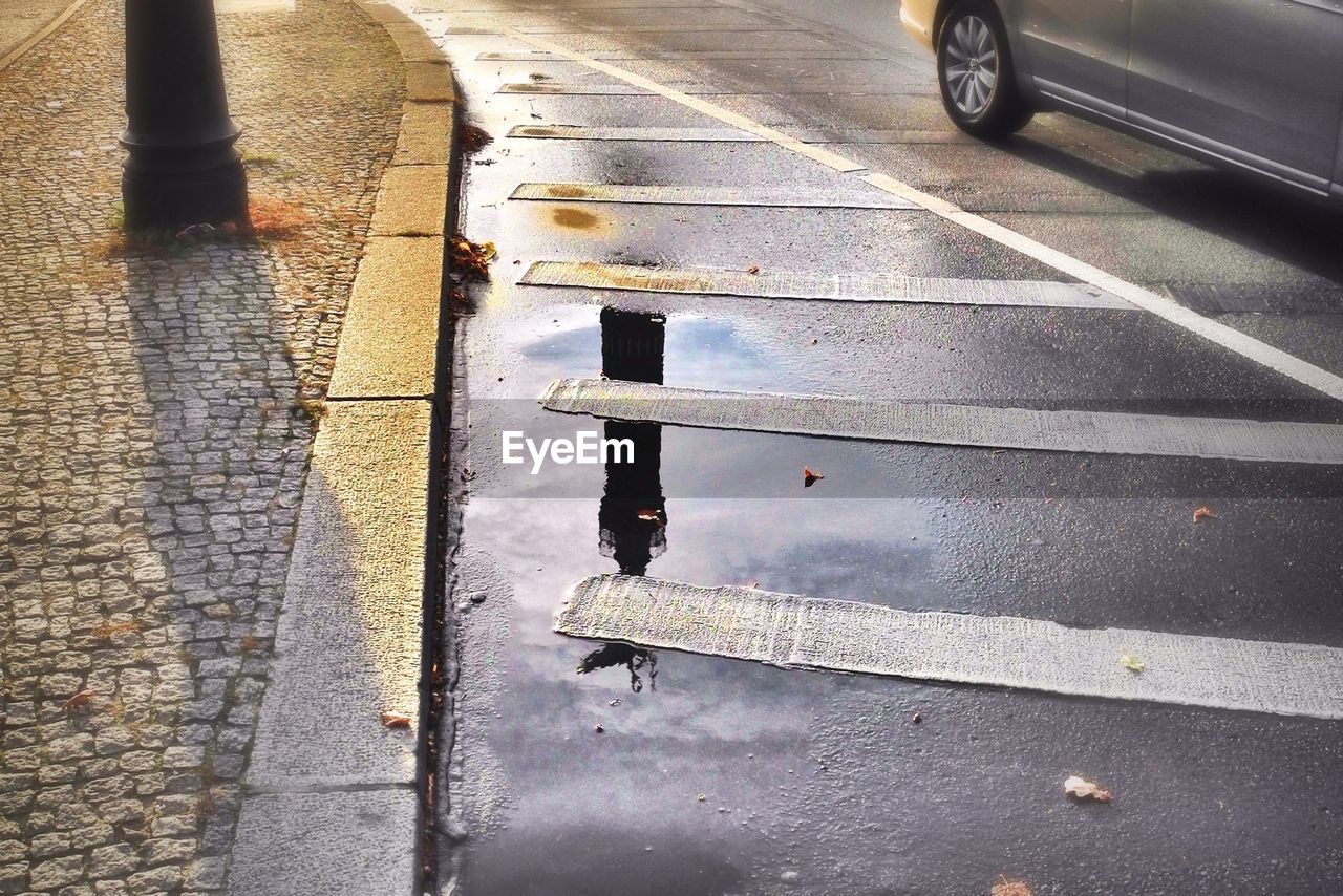 High angle view of puddle on street with road markings