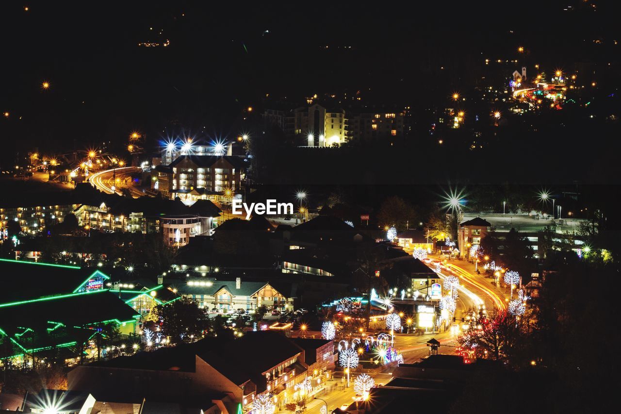 Illuminated cityscape against sky at night