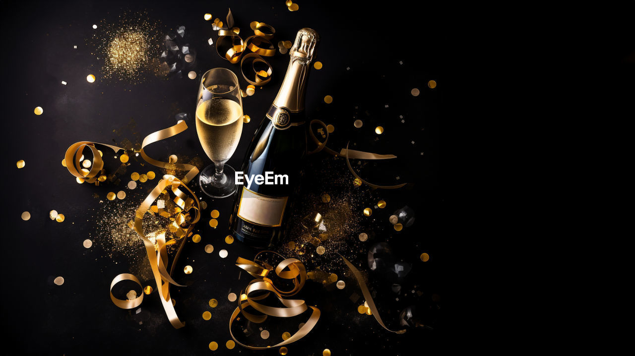 black background, darkness, studio shot, food and drink, indoors, light, no people, motion, night, font, yellow, copy space, drink, bottle, still life photography, gold, dark, refreshment