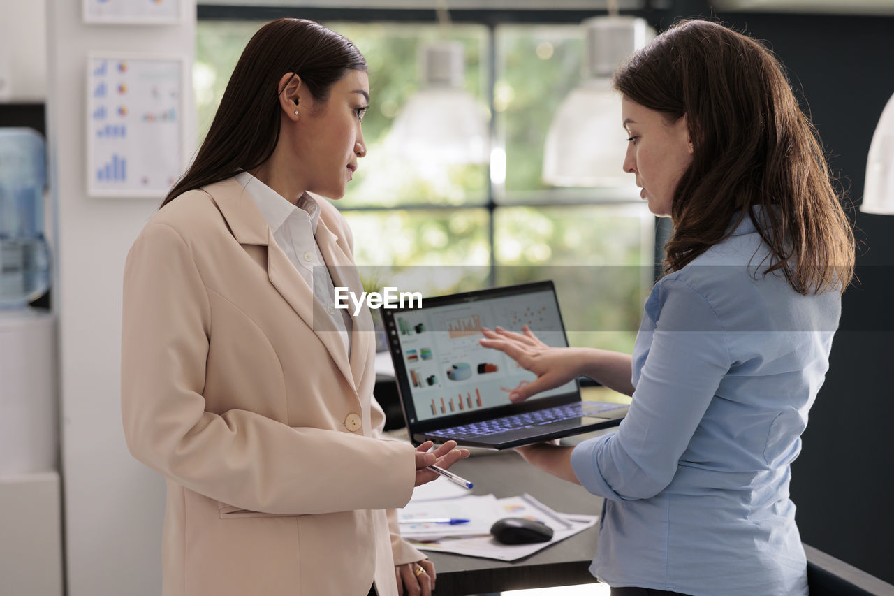 portrait of young woman using laptop at office