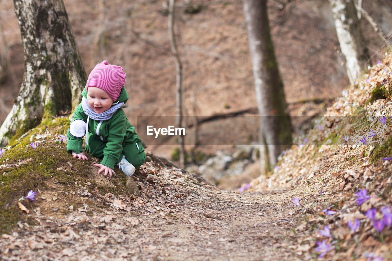 Cute toddler baby on spring forest full of wild irises. spring blossom in the forest. harmony, hope