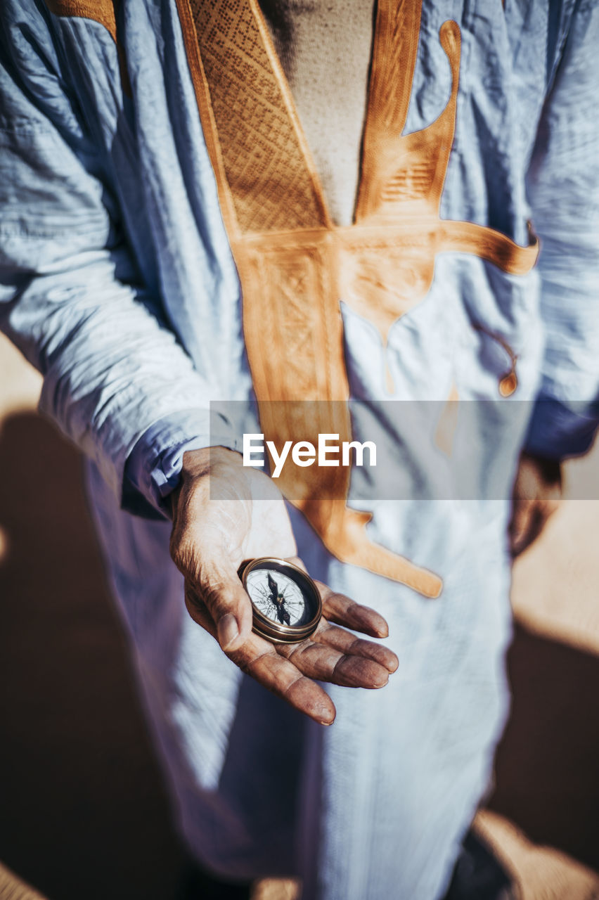 Close-up of senior man holding compass in smara refugee camp, tindouf, algeria