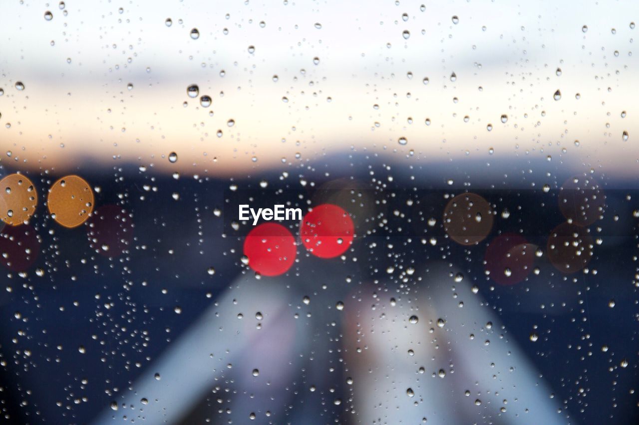 Close-up of wet glass window during rainy season