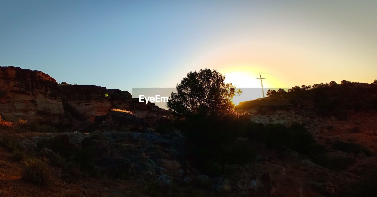 SCENIC VIEW OF MOUNTAIN AGAINST CLEAR SKY DURING SUNSET