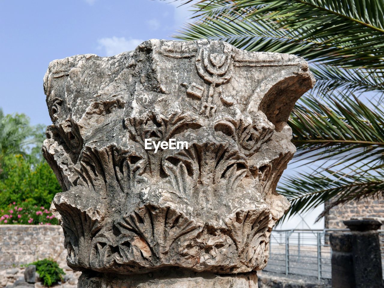 CLOSE-UP OF ANGEL STATUE WITH PALM TREE