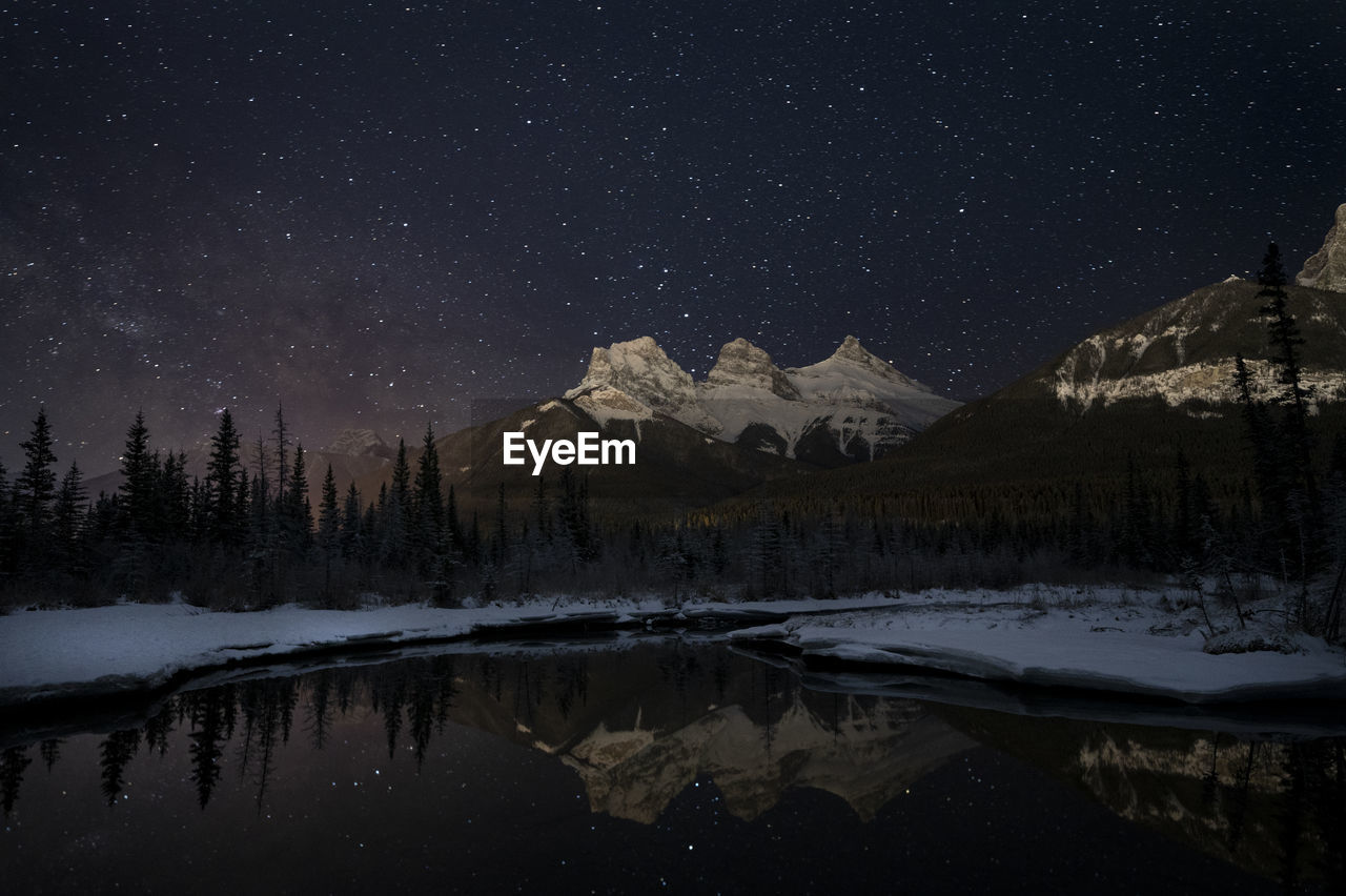 Scenic view of snowcapped mountains against sky at night