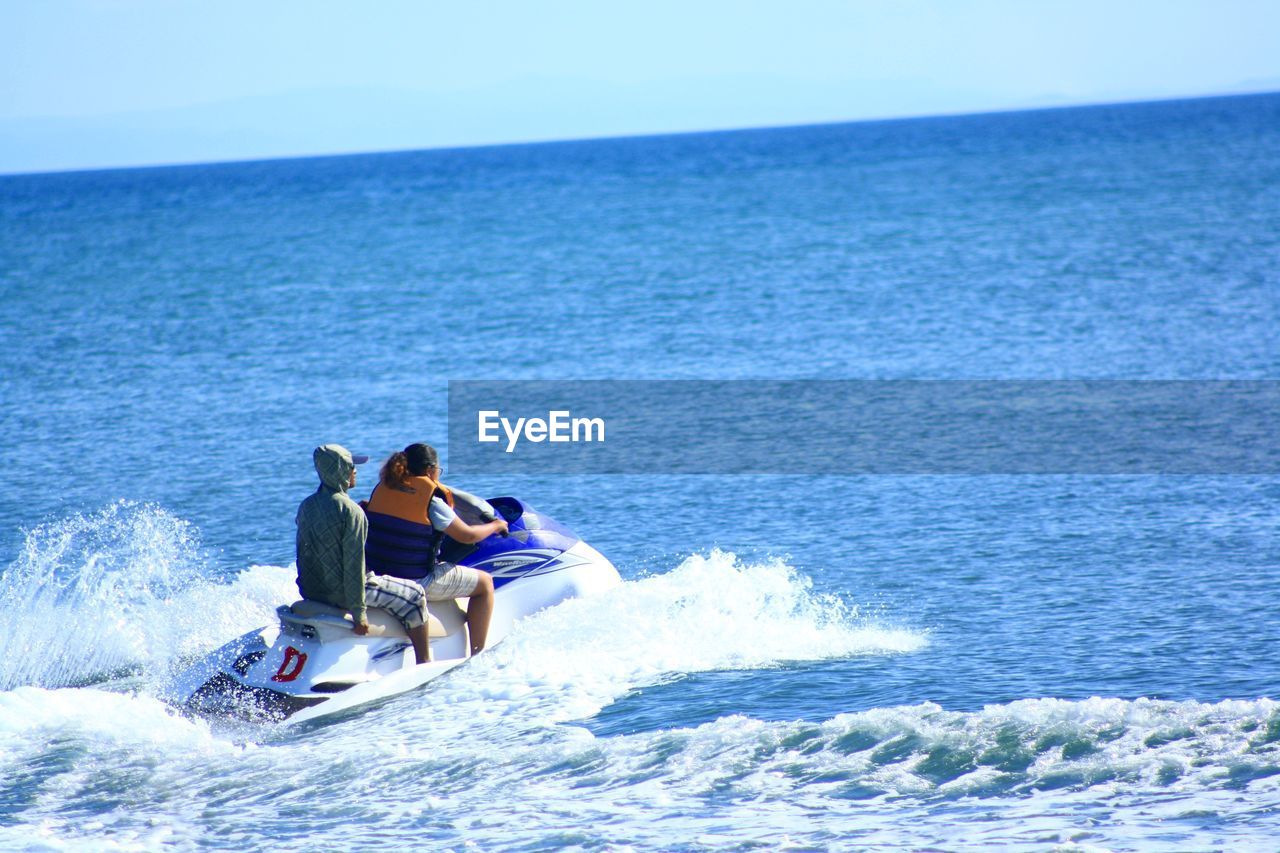 PEOPLE ON SEA AGAINST CLEAR SKY