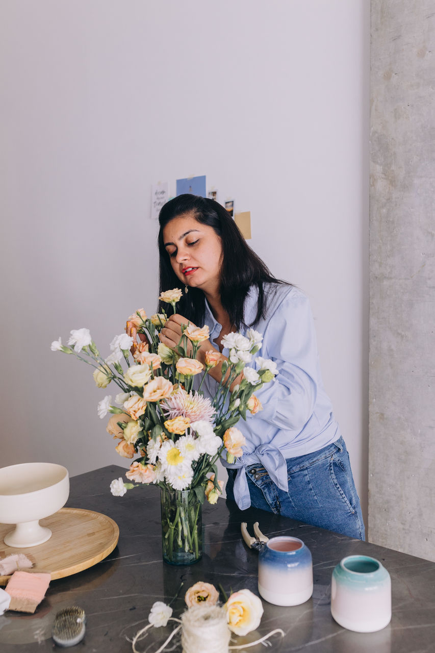 Indian ethnicity woman creating a bouquet of flowers 