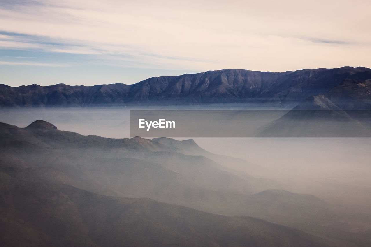 Scenic view of rocky mountains against sky during foggy weather