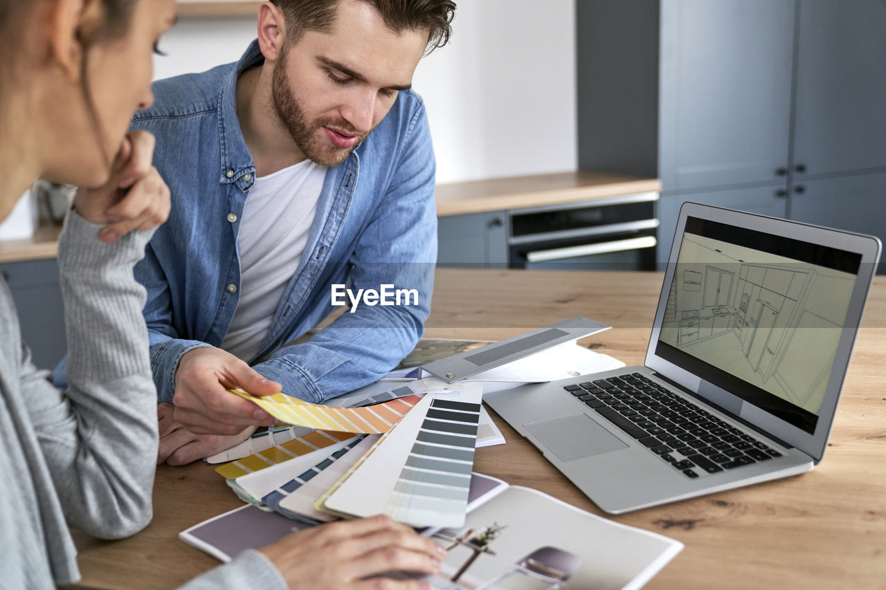 side view of man using laptop at office