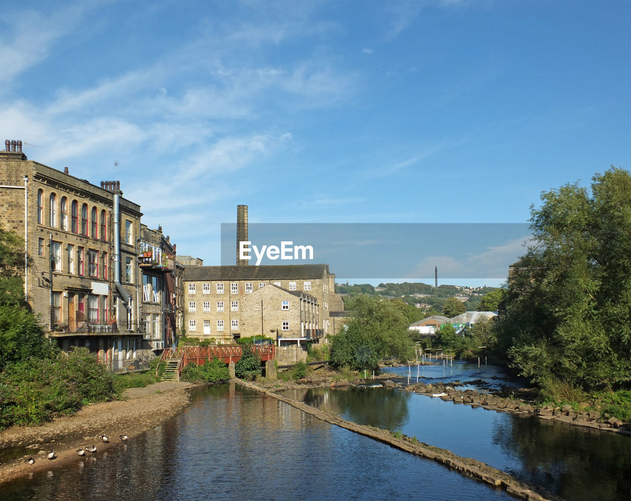 BUILDINGS BY RIVER AGAINST SKY