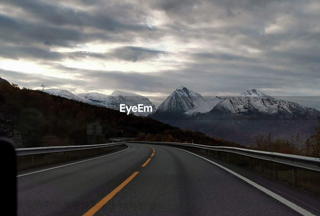 ROAD BY SNOWCAPPED MOUNTAIN AGAINST SKY