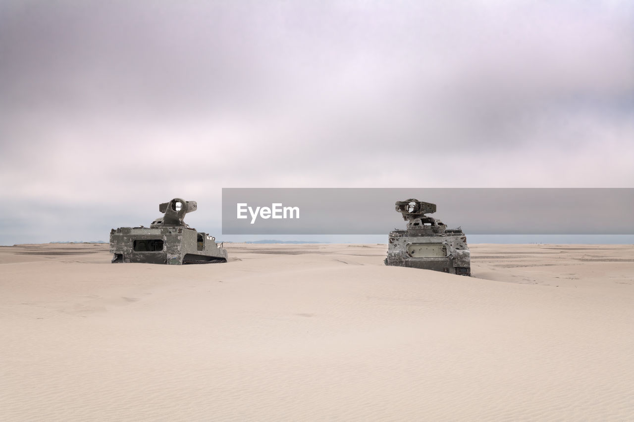2 army tanks on the beach with bullet holes