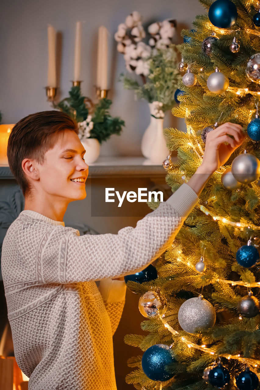 Full length of smiling boy in christmas tree