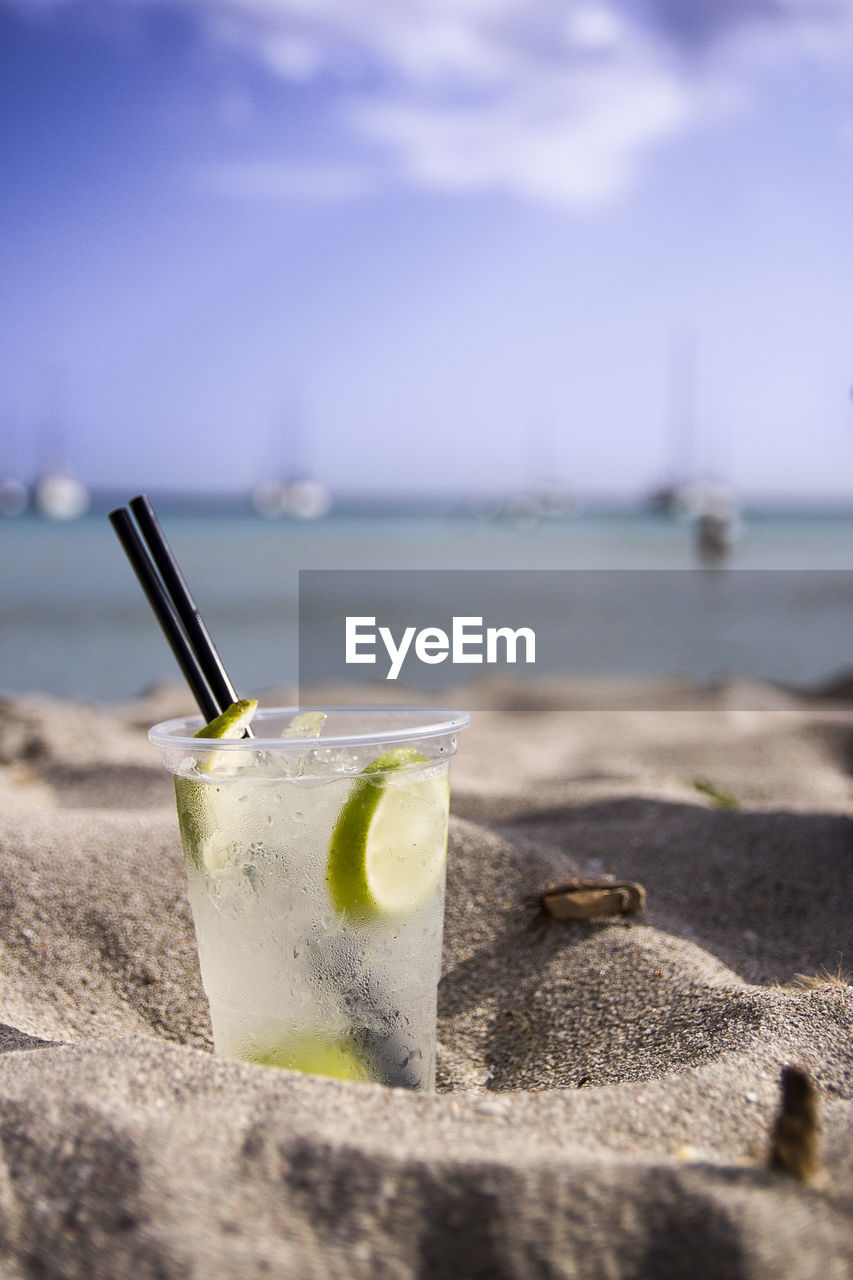 High angle view of drink on table at beach against sky