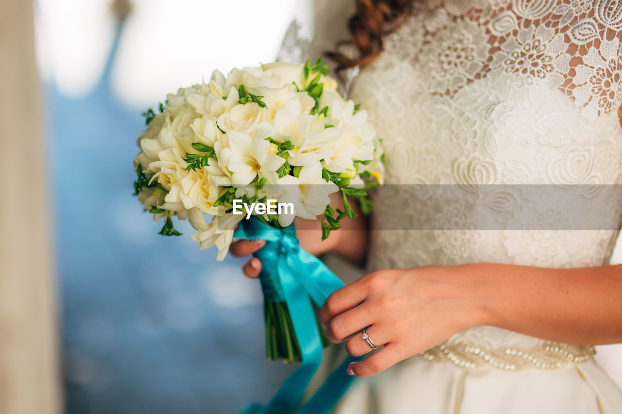 Midsection of woman holding flower bouquet