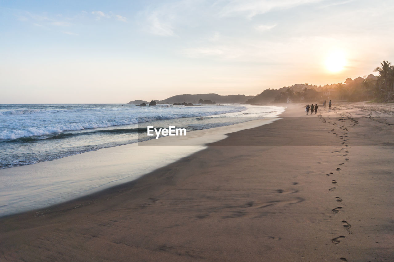 SCENIC VIEW OF BEACH AT SUNSET