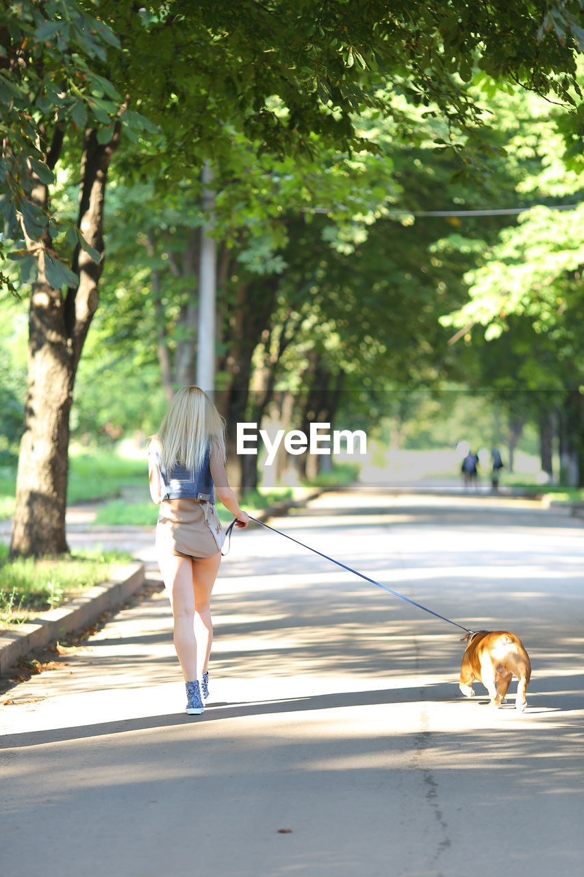 Rear view of woman walking on road