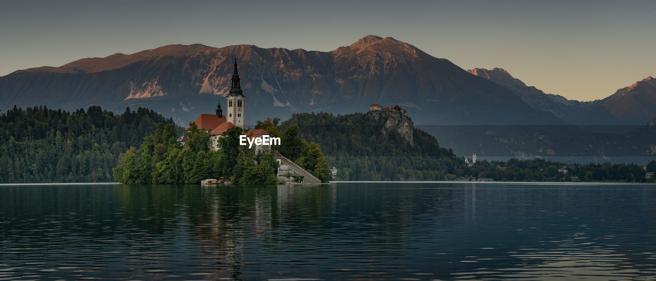 Scenic view of lake by mountains against sky