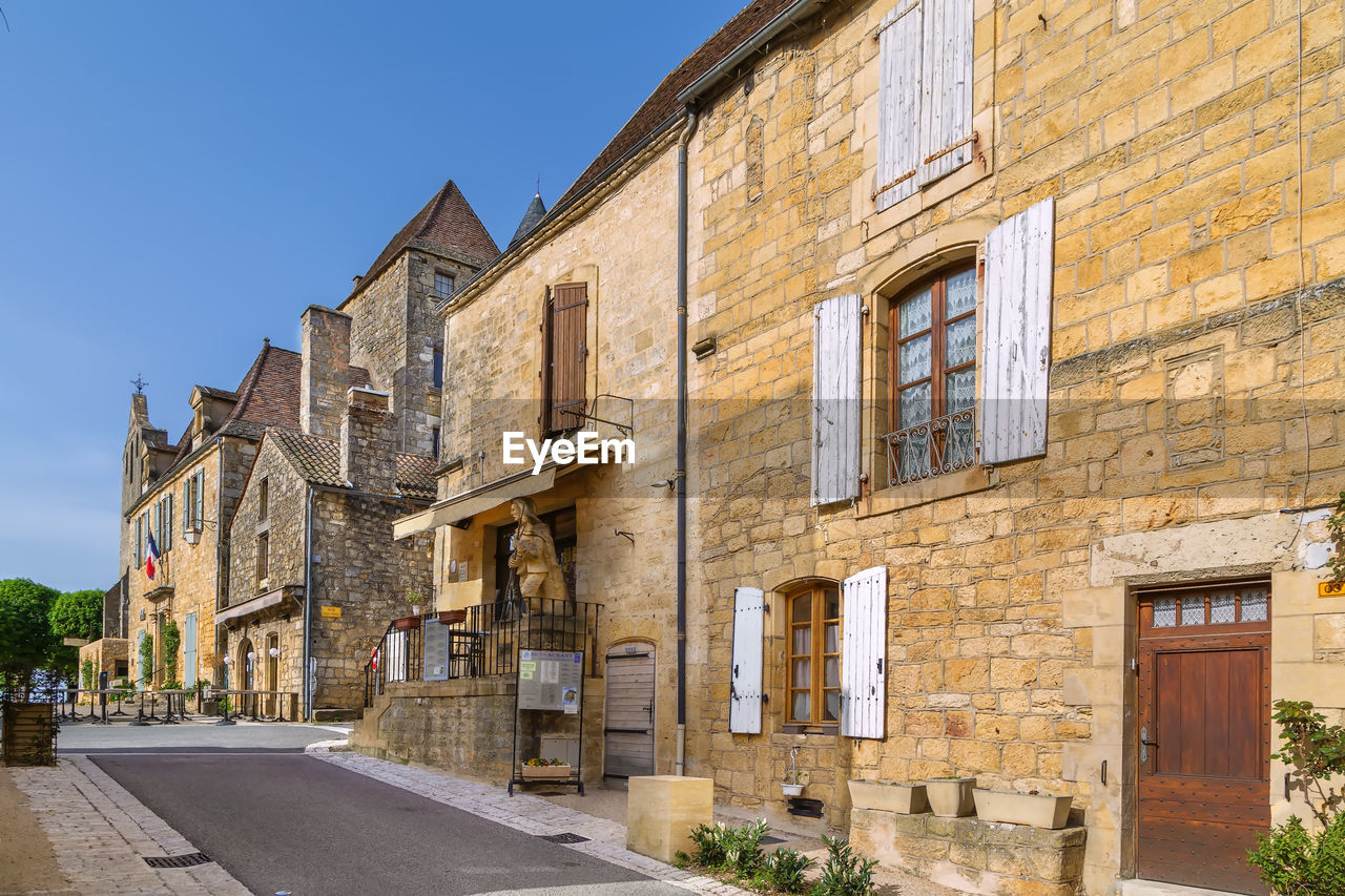 Street with historical houses in domme commune in the dordogne department, france