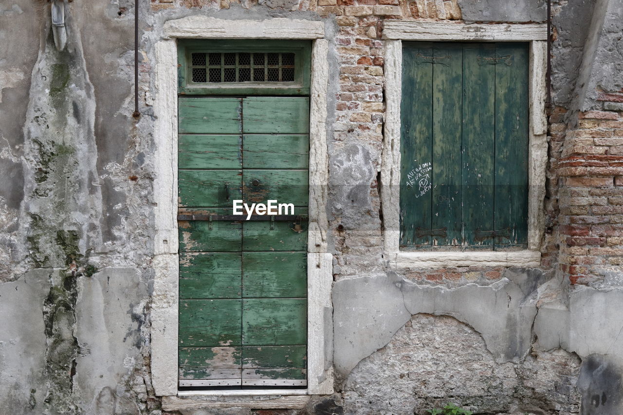 CLOSED WINDOW OF OLD ABANDONED HOUSE