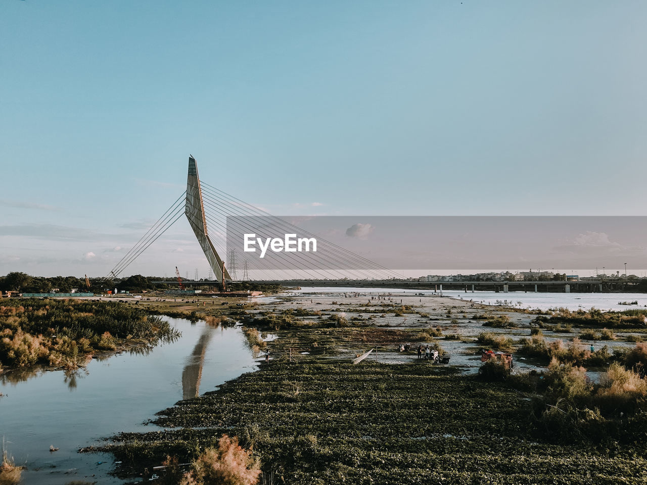 BRIDGE OVER LAKE AGAINST SKY