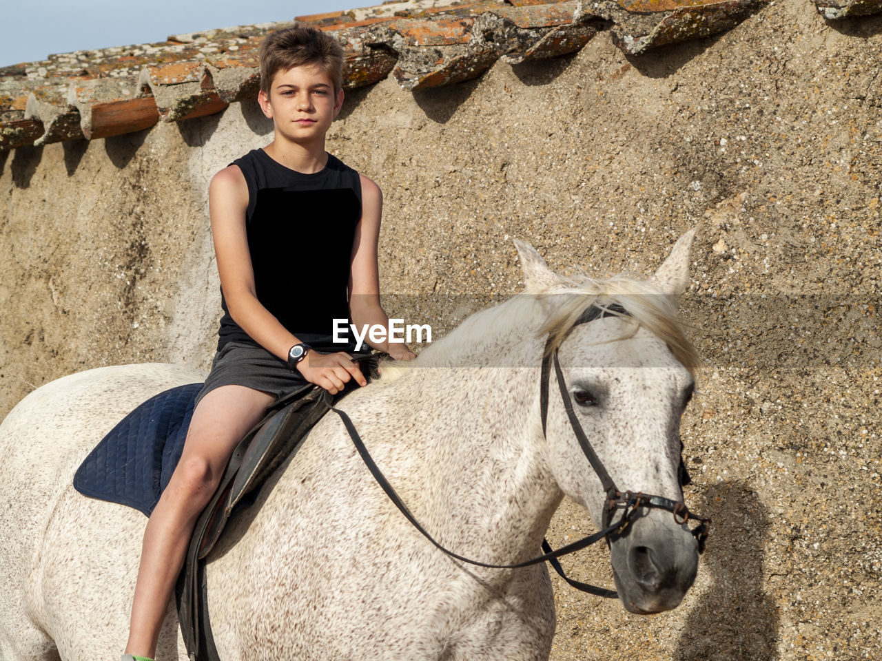Portrait of boy riding horse