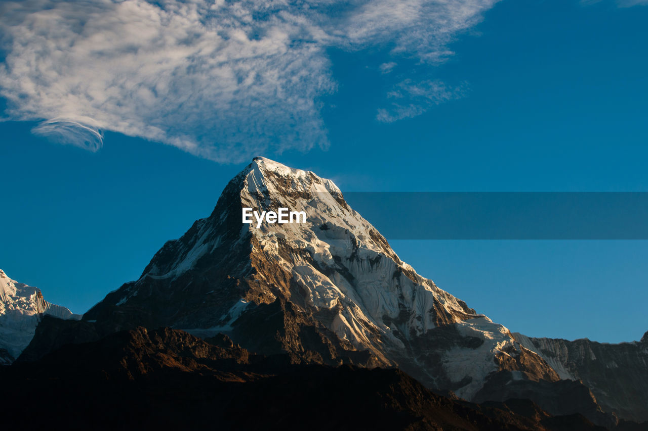 Scenic view of snowcapped mountains against blue sky