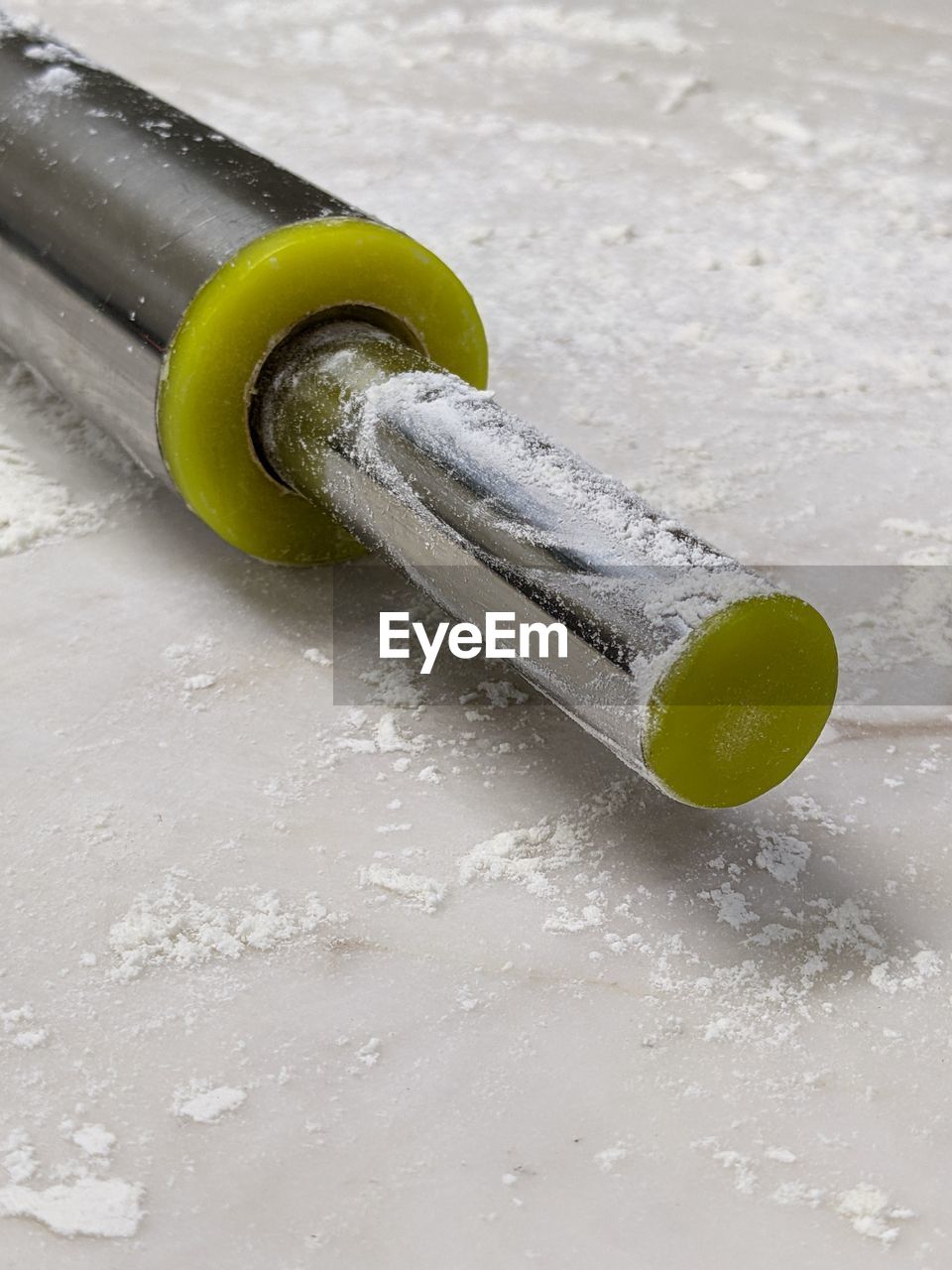 Close-up of rolling pin and flour on the table