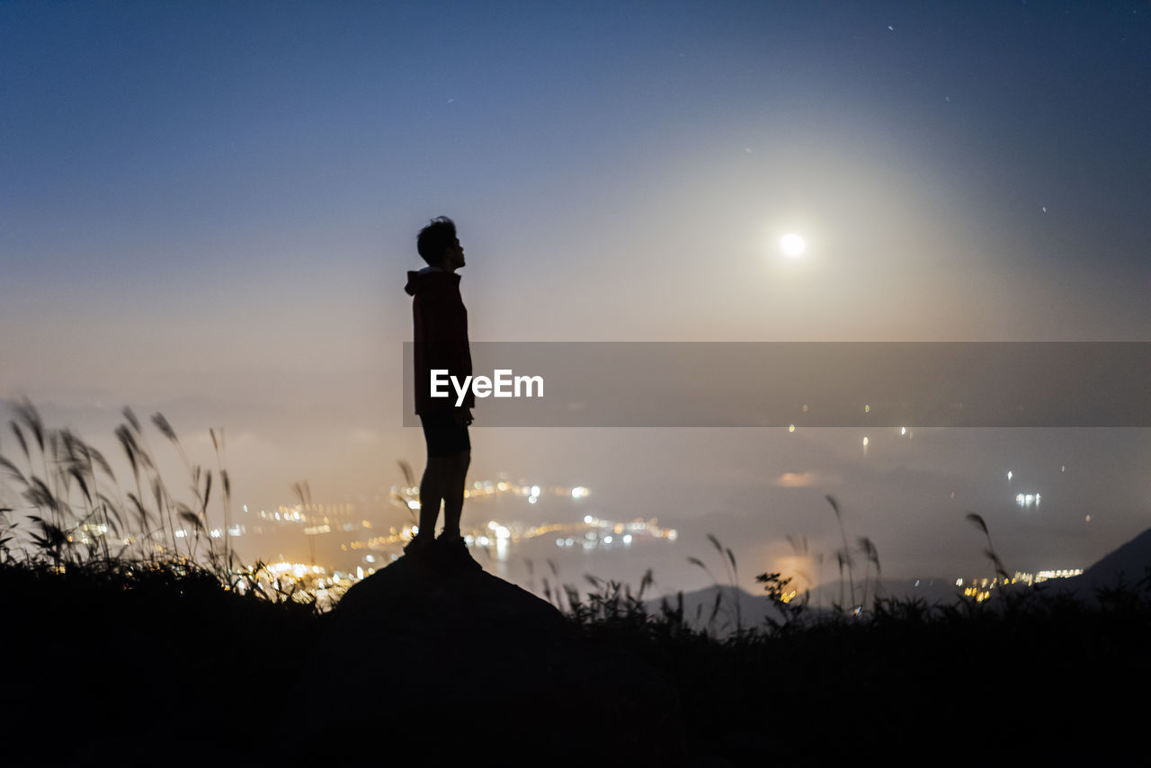 Silhouette man standing against sky at night