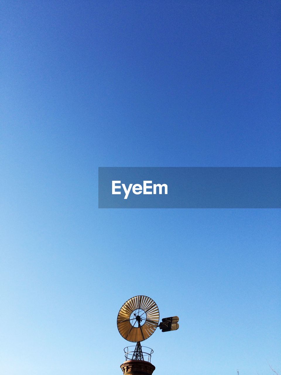 High section of windmill against clear blue sky