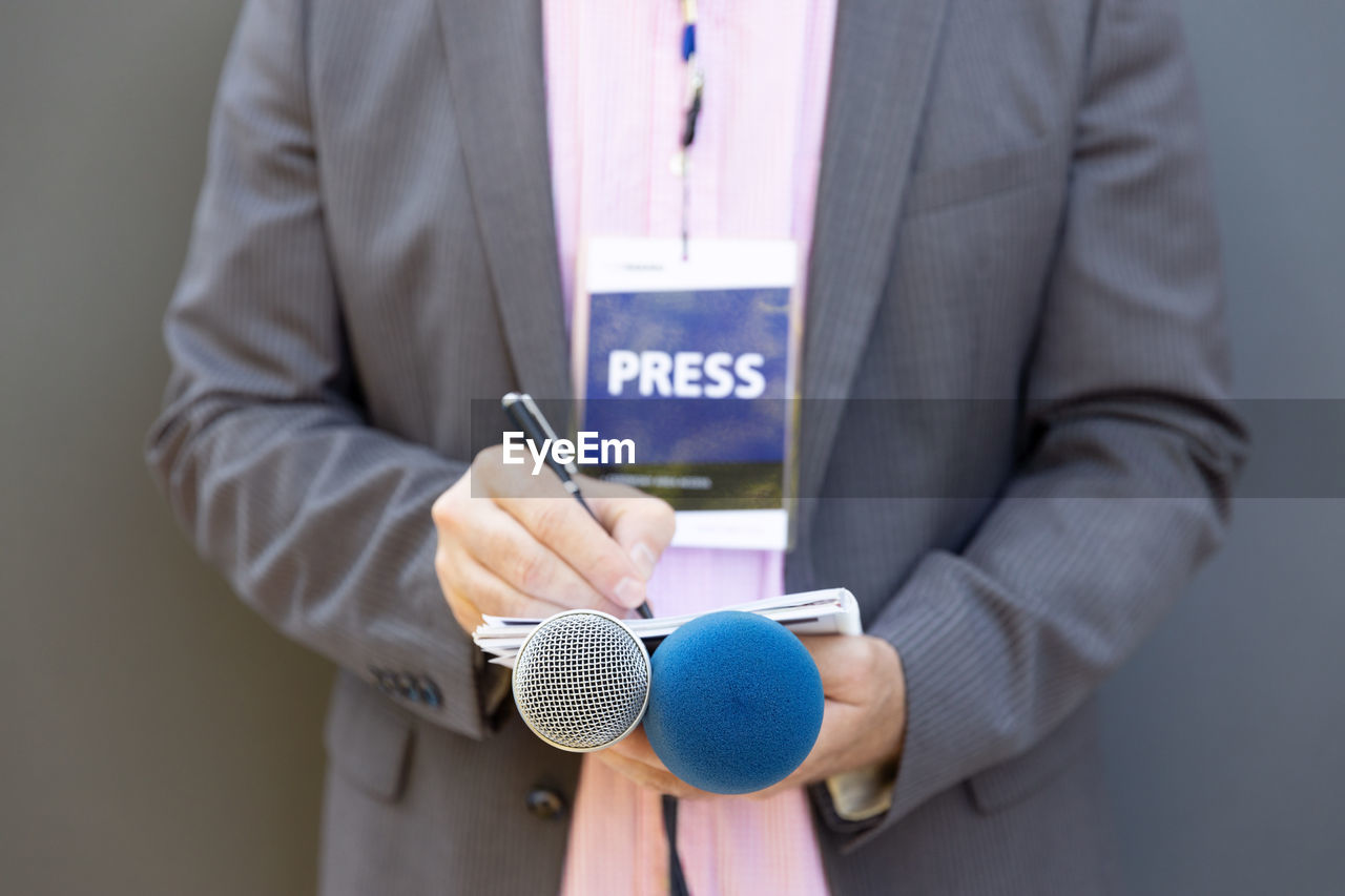 MIDSECTION OF MAN HOLDING SMART PHONE