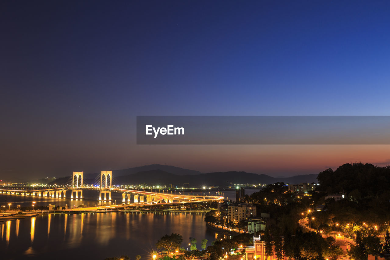 Illuminated sai van bridge at night against clear sky