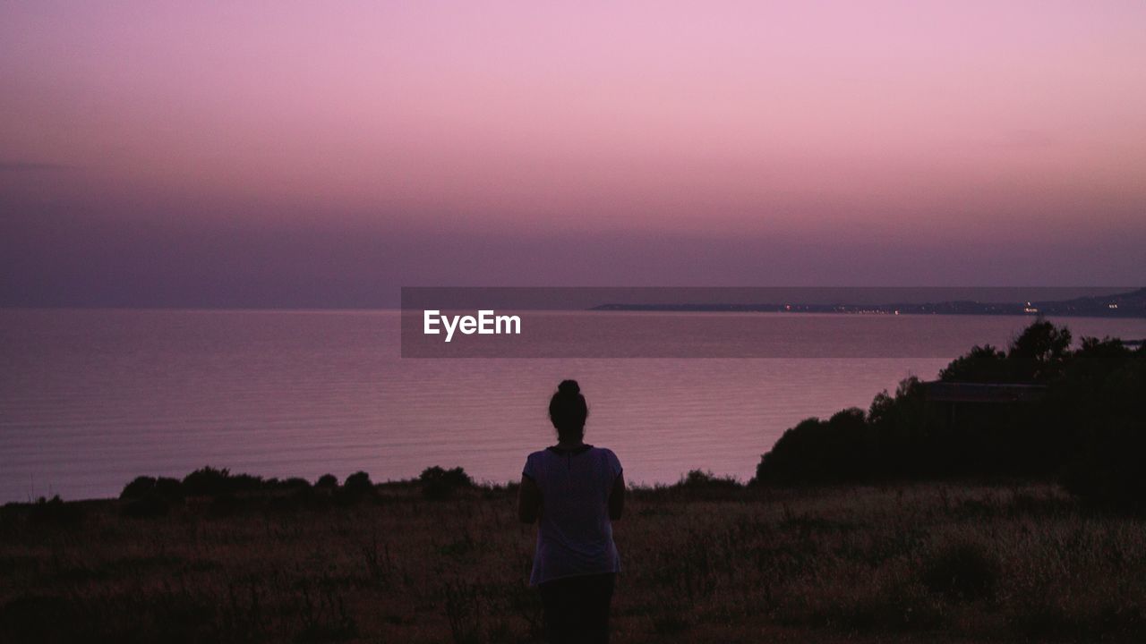 Rear view of woman on landscape against sky