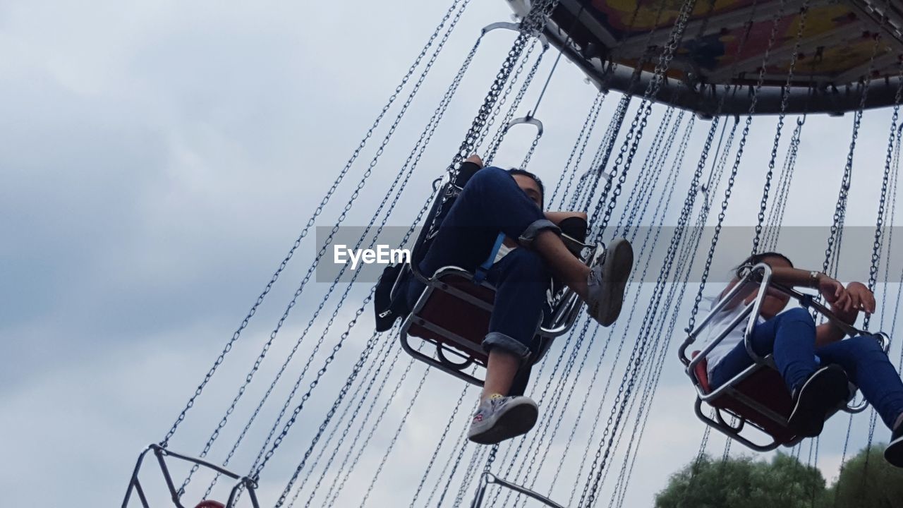 Low angle view of swing ride at amusement park