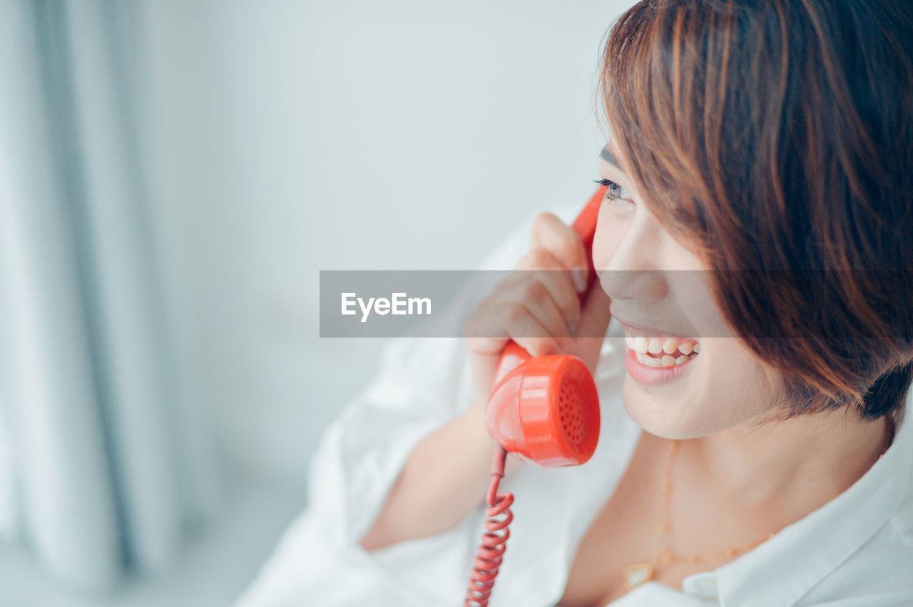 Close-up of smiling woman talking on telephone